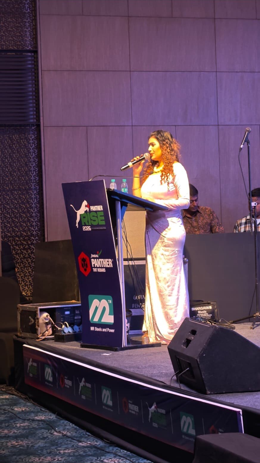 Anchor addressing guests at a corporate conference stage