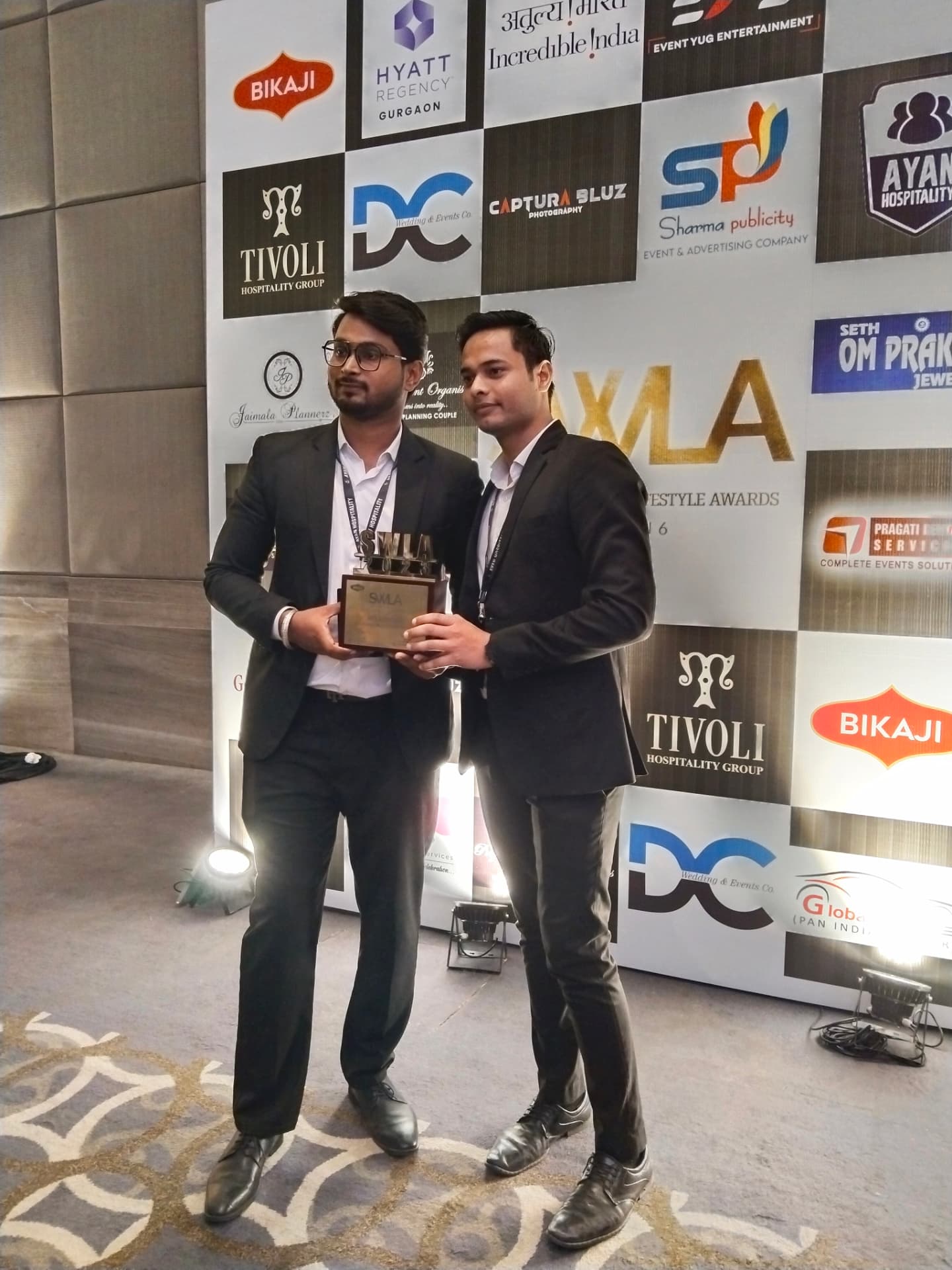 Harmony founders with the SWLA award at the sponsor wall